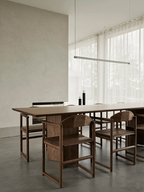 Erik dining chairs in solid dark oak around the Ann dining table in a minimalist Scandinavian dining room