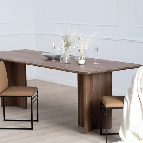Ann dining table in dark oak with elegant glassware and floral decor, enhancing dining room sophistication.