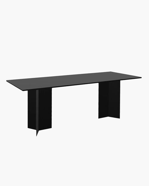 Ann dining table in black oak featuring a bold, modern design with sleek, sculptural lines.