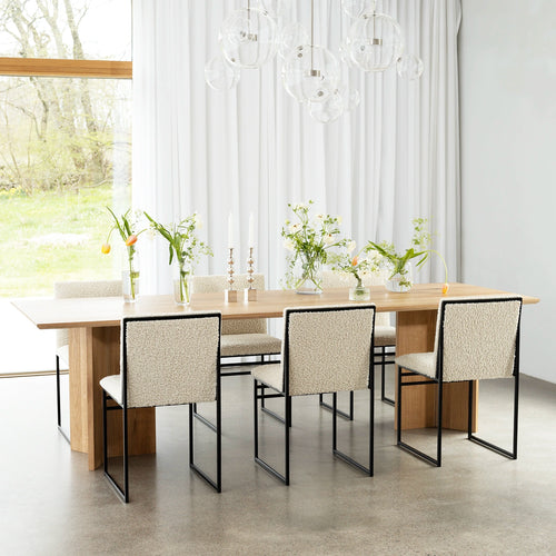 Ann dining table in oak with stylish chairs, enhancing a bright dining space with natural warmth and elegance.