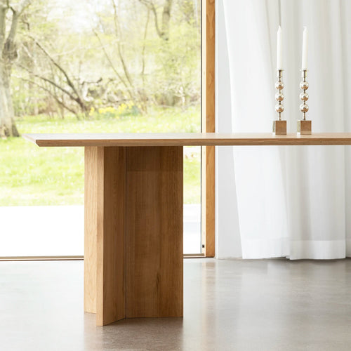 Ann dining table in oak, showcasing natural warmth and elegant design in a bright dining space.