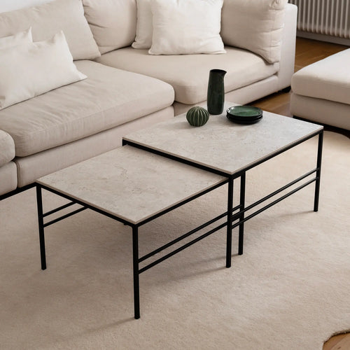 Minimalist Anton Coffee Table set in Sabbia Dekton with black frame by by Crea. Two-piece nesting tables styled in a Scandinavian living room, showcasing soft neutral tones and timeless handmade design.