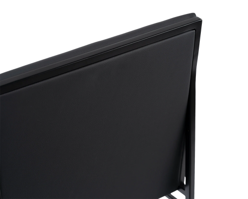 Close-up of the Bella Dining Chair backrest by by Crea, featuring smooth black vegan leather upholstery framed by a sleek black steel structure, showcasing the chair’s refined Scandinavian craftsmanship.