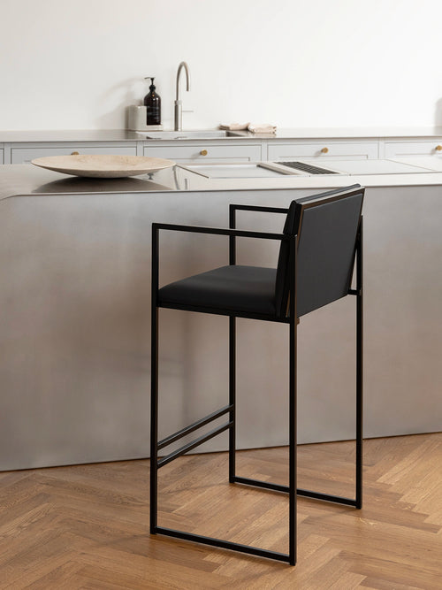 Bar Stool Bruno – Black – Jade Black Leather at a kitchen counter with minimal design and sleek frame.