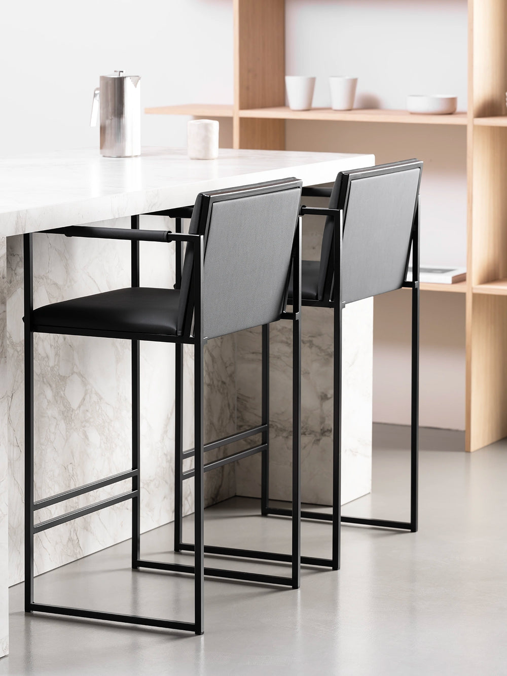 Bar Stool Bruno – Black – Jade Black Leather with sleek design and modern matte black frame at a kitchen counter.