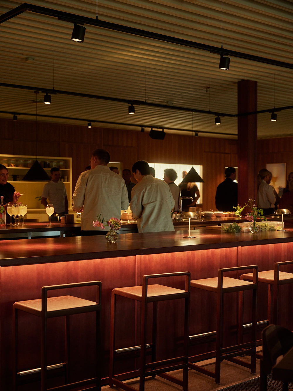Guests gathered around the bar at Norrbottens Destilleri, with Ebba bar stools from by Crea in the foreground.
