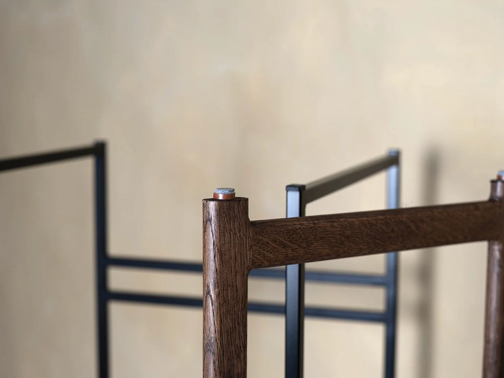 Close-up of Crea furniture pads installed on a wooden barstool leg for floor protection and stability.