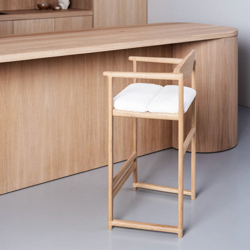 Minimalist oak bar stool with ivory bouclé upholstery, designed for modern comfort and daily use.