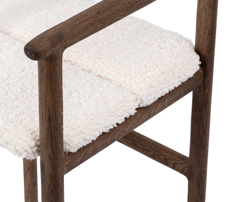Side view detail of Carl Bar Stool armrest, frame in dark oak with ivory bouclé cushion | by Crea.