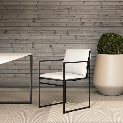 Outdoor chair Elsy in black frame with marble acrylic cushion in modern outdoor setting.