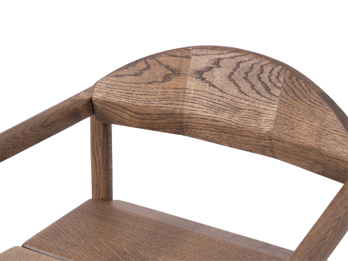 Close-up of Erik Dining Chair backrest in solid dark oak, highlighting the curved woodwork and fine grain detail | by Crea.