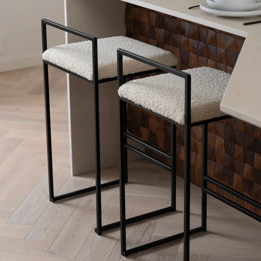 Breakfast Bar Stool Freja with black frame and ivory bouclé cushions at a kitchen counter.