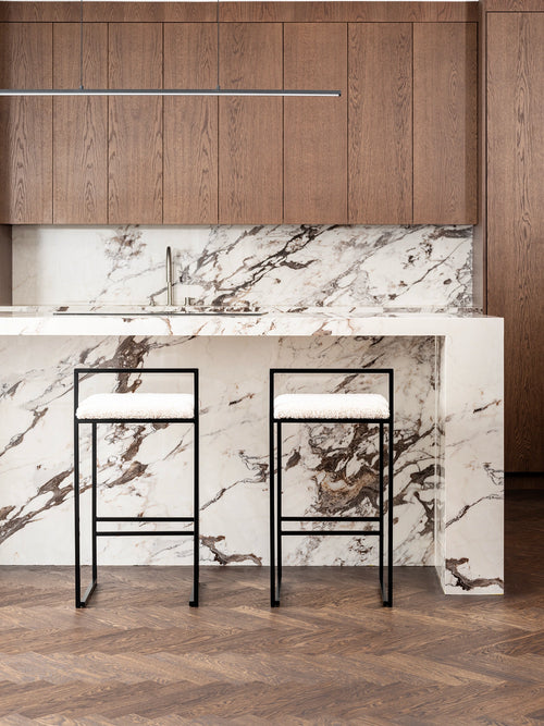 Breakfast Bar Stool Freja with black frame and ivory bouclé cushion in modern kitchen setting.