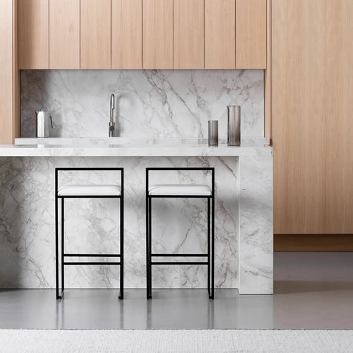 Freja bar stool with black steel frame and ivory leather cushion in a modern kitchen setting.
