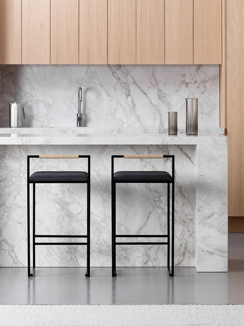 Kitchen Bar Stool Freja with black frame and leather cushion in modern kitchen setting.