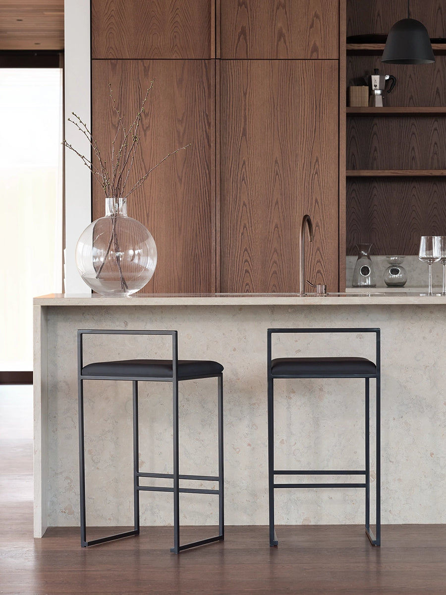 Bar Stool Freja with black frame and jade black leather cushion in a modern kitchen setting.