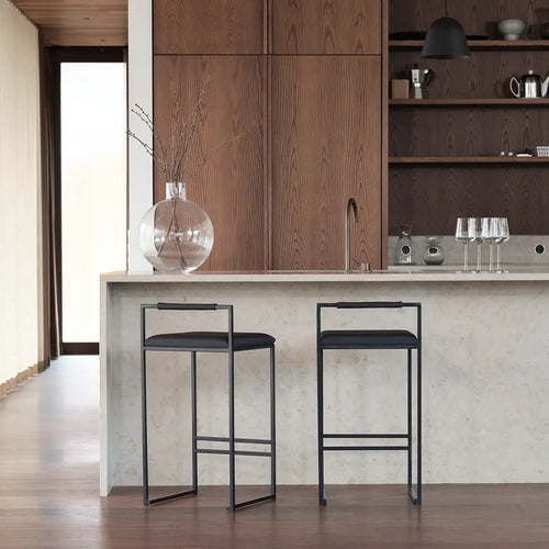 Freja bar stool with black frame and leather cushion in modern kitchen setting.