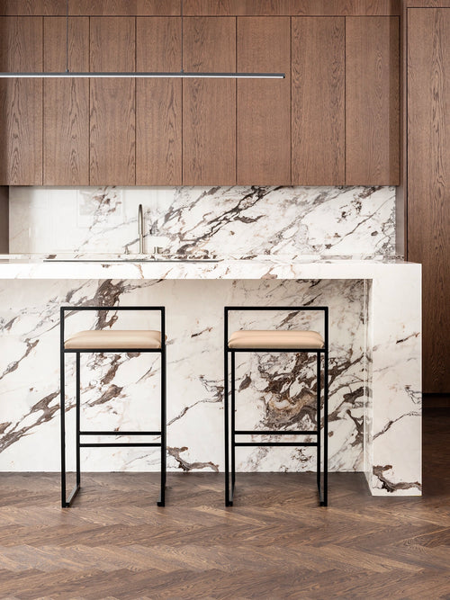Leather Bar Stool Freja with black frame and latte cushion in a modern kitchen setting.