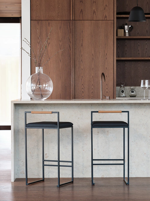 Bar Stool Freja with black frame and leather cushion in a modern kitchen setting.