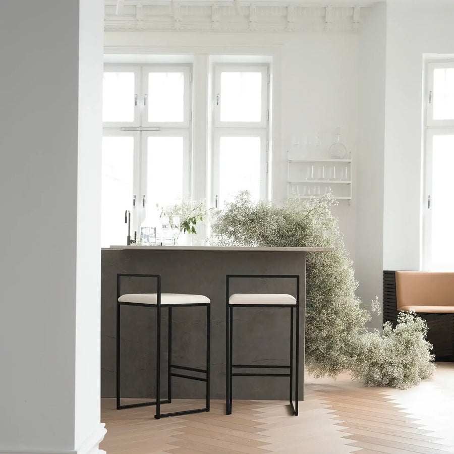 Bar Chair Freja with black frame and ivory leather cushion at modern kitchen island.