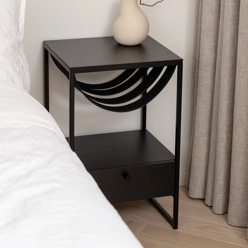 Iris bed table in black with sleek design, featuring a drawer and minimalist style, perfect for modern bedrooms.