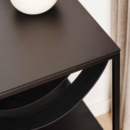 Close-up of the sleek black Iris bed table showcasing modern minimalism and a stylish round top.