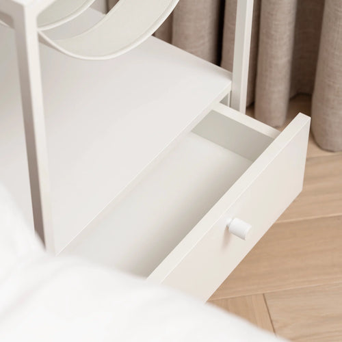 Iris bed table in white featuring a minimalist design and open drawer, perfect for modern bedroom interiors.