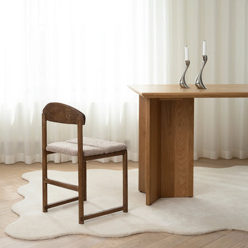 Karin dining chair in dark oak with greige bouclé, paired with modern table and elegant decor.