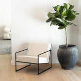 Kent armchair in soft ivory leather with a black frame, showcasing Scandinavian design in a modern living space.