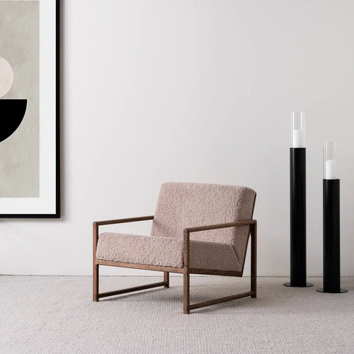 Armchair Einar with dark oak frame and greige bouclé cushion in a stylish interior setting.