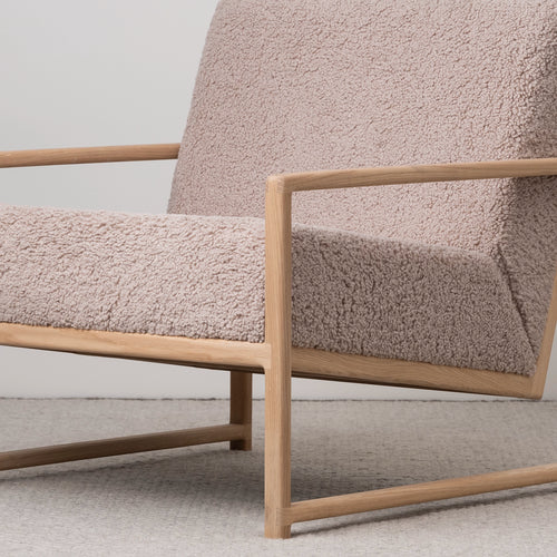 Scandinavian oak armchair featuring soft greige bouclé, ideal for modern living and reading corners.