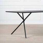 Melker Dining table in black oak with stylish cross legs, perfect for modern dining spaces.