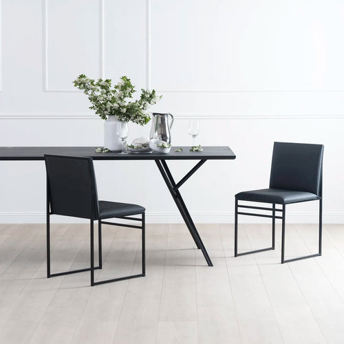 Melker Dining table in black oak with sleek black chairs and floral centerpiece, ideal for modern dining spaces.