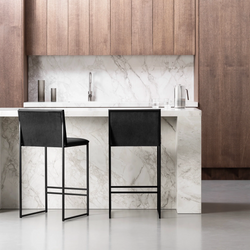 Black Philip bar stools with black velvet seats at a modern marble kitchen island, showcasing contemporary design and comfort.