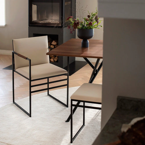 Sella dining chair with black frame and latte leather, featuring chocolate-toned armrest, modern dining room setting.