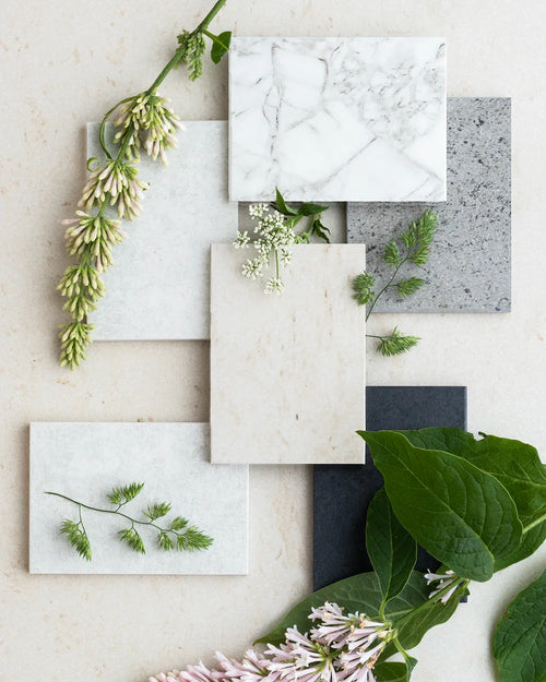 Various Dekton stone samples with natural greenery to help choose the perfect surface.