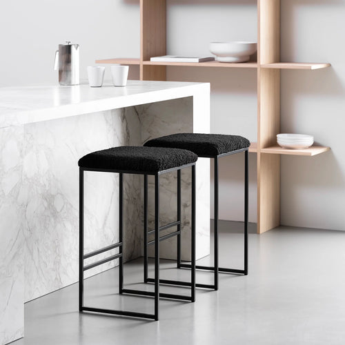 Svea black bar stools featuring a stylish black bouclé seat and a sleek black frame, ideal for modern high seating.