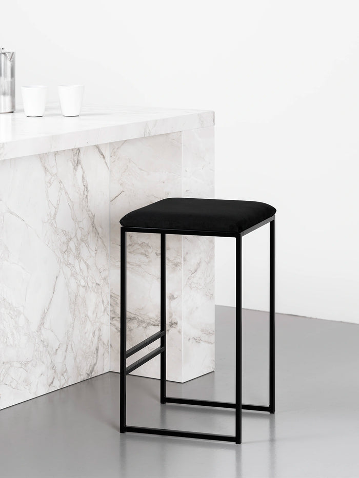 Bar Stool Svea – Black – Jade Black Velvet against a marble counter, modern design for stylish seating.