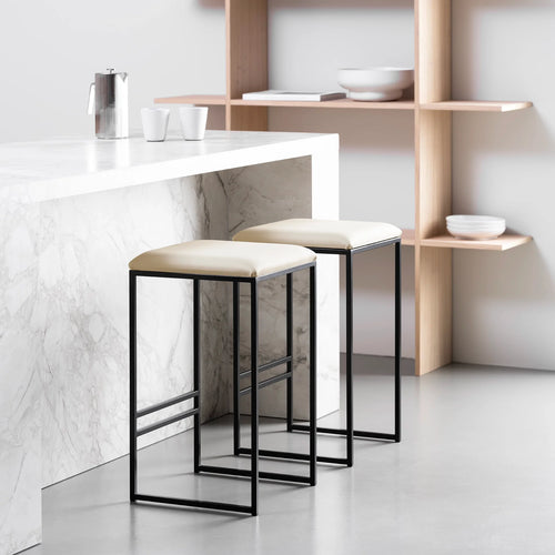 Svea bar stools featuring a black frame and sand leather seat, ideal for a modern kitchen setup.