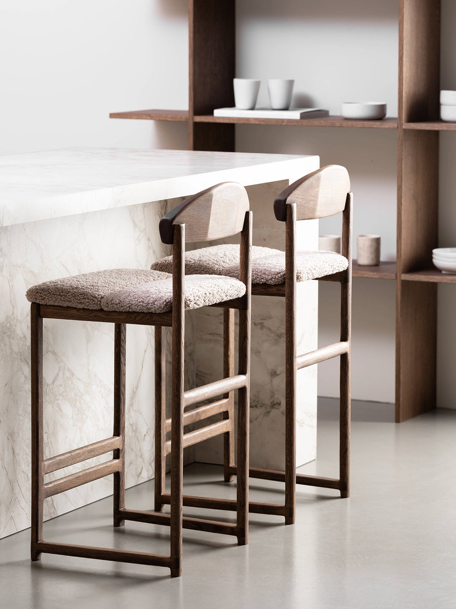 Oak Bar Stool with greige bouclé seat in stylish dining space with marble countertop.