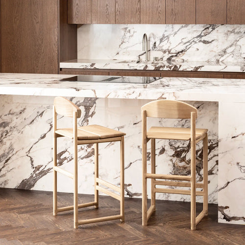 Ted bar stool in solid oak, minimalistic design, stylishly placed at a modern kitchen island with marble countertop.