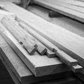 Black and white close-up of oak wood pieces precisely cut for joinery, showcasing the handcrafted quality and sustainable solid wood construction used in by Crea furniture.