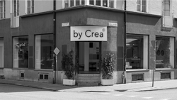 Black and white photo of the by Crea flagship store located on Jörgen Ankersgatan in Malmö, Sweden, featuring a minimalist entrance flanked by two windows displaying handcrafted Scandinavian furniture.