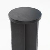 Pedestal Affe in black oak, showcasing its elegant minimalistic design and smooth round top.