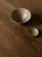 Close-up detail of the Ann dining table in solid dark oak styled in a Danish design apartment in Copenhagen.