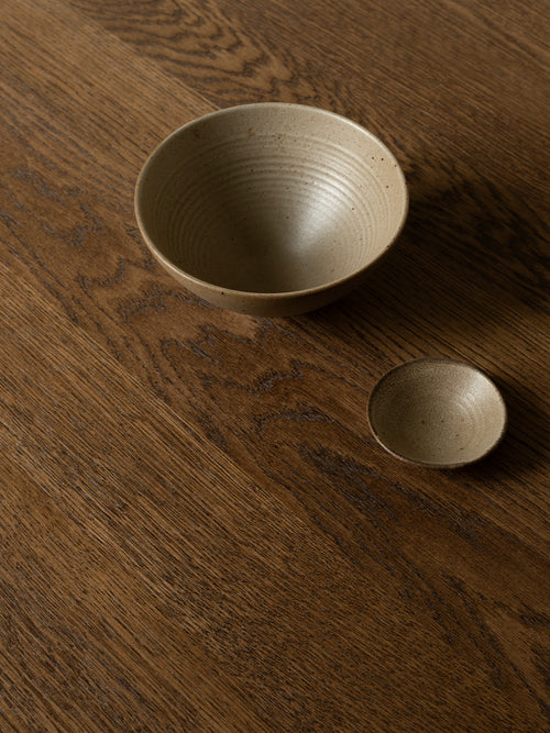 Close-up detail of the Ann dining table in solid dark oak styled in a Danish design apartment in Copenhagen.