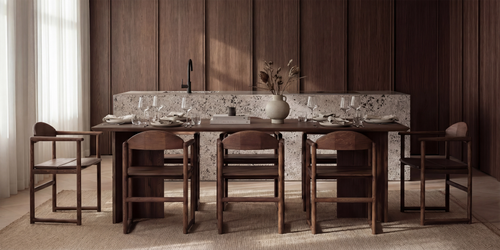 Minimalist Scandinavian dining space with the Ann dining table in dark oak paired with Erik chairs in solid oak, styled against a terrazzo kitchen island and warm-toned wood panel cabinetry.