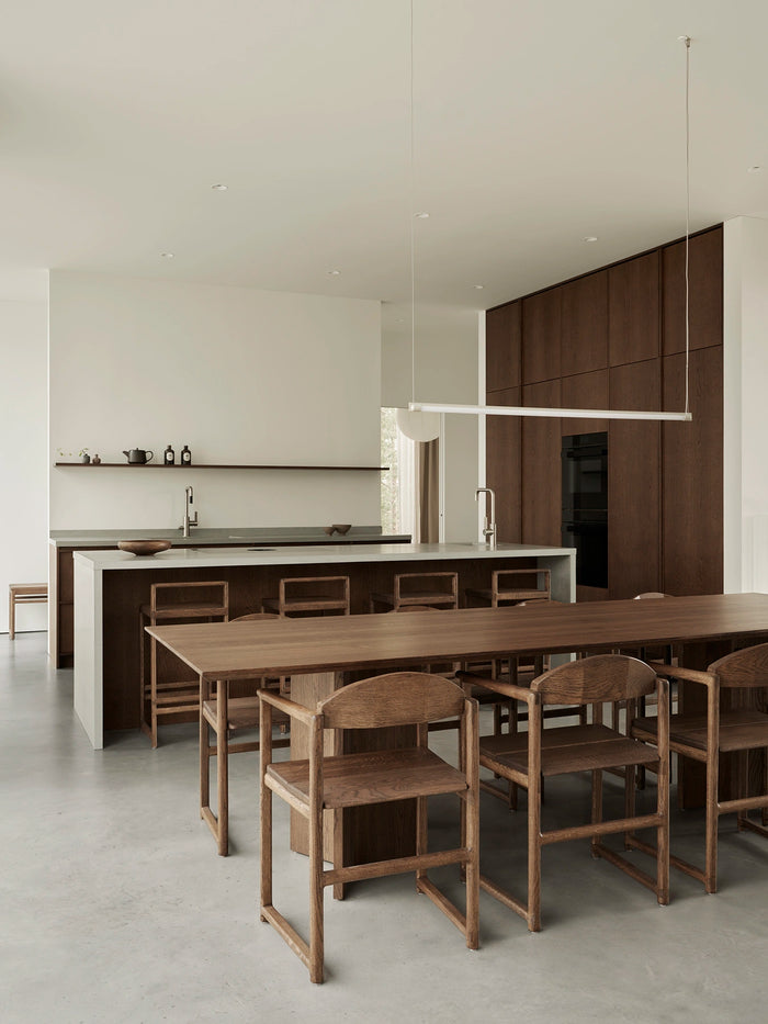 Erik dining chairs and Ebba bar stools in dark oak in a Scandinavian kitchen with oak cabinetry