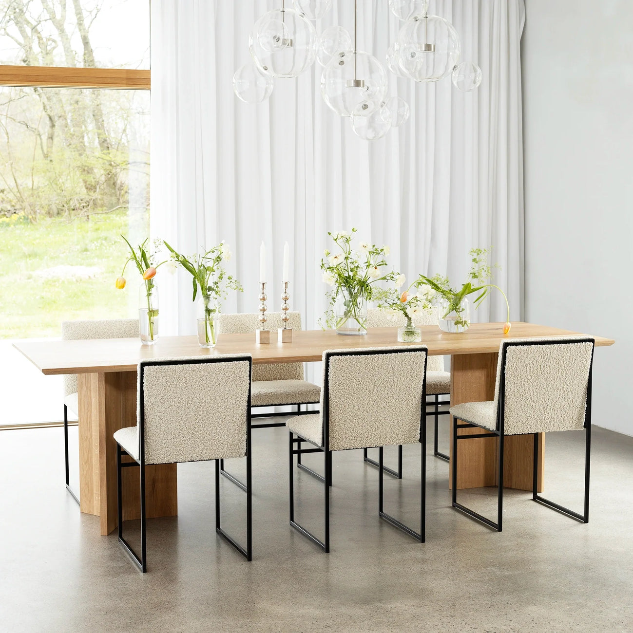 Ann dining table in oak with stylish chairs, enhancing a bright dining space with natural warmth and elegance.