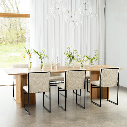 Ann dining table in oak with stylish chairs, enhancing a bright dining space with natural warmth and elegance.
